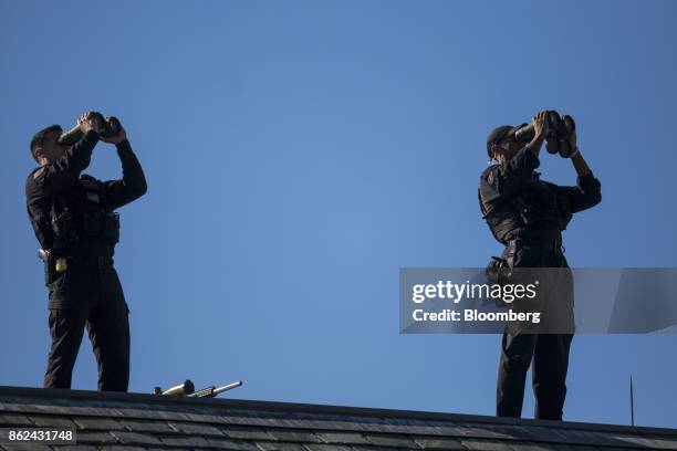 Members of the U.S. Secret Service use binoculars while standing on the roof of the West Wing of the White House in Washington, D.C., U.S., on...