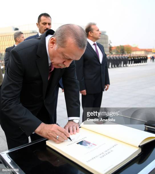President of Turkey, Recep Tayyip Erdogan , signs the guest book during his visit at the Tomb of the Unknown Soldier in Warsaw, Poland on October 17,...