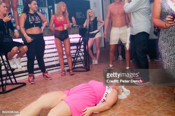 Jody from Manchester, lies on the floor at Barcode bar during a game to celebrate her hen party in Ayia Napa, Cyprus. She is accompanied on the trip...