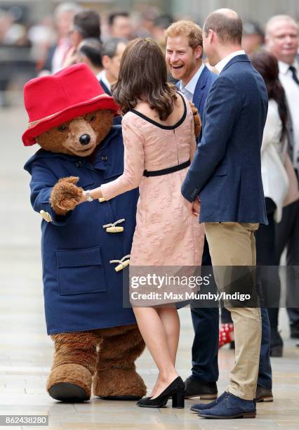 Catherine, Duchess of Cambridge dances with Paddington Bear, watched by Prince William, Duke of Cambridge and Prince Harry as they attend the...