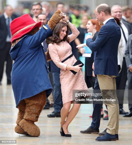 Catherine, Duchess of Cambridge dances with Paddington Bear, watched by Prince William, Duke of Cambridge and Prince Harry as they attend the...