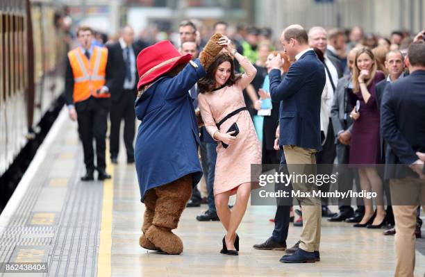 Catherine, Duchess of Cambridge dances with Paddington Bear, watched by Prince William, Duke of Cambridge and Prince Harry as they attend the...