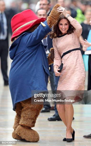 Catherine, Duchess of Cambridge dances with Paddington Bear as she attends the Charities Forum Event at Paddington Station on October 16, 2017 in...