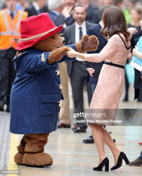 Catherine, Duchess of Cambridge dances with Paddington Bear as she attends the Charities Forum Event at Paddington Station on October 16, 2017 in...