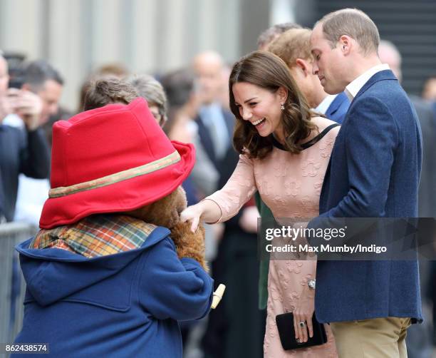 Prince William, Duke of Cambridge looks on as Paddington Bear kisses Catherine, Duchess of Cambridge's hand whilst they attend the Charities Forum...