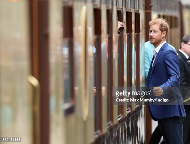 Prince Harry talks to a passenger onboard the Belmond British Pullman train as he attends the Charities Forum Event at Paddington Station on October...