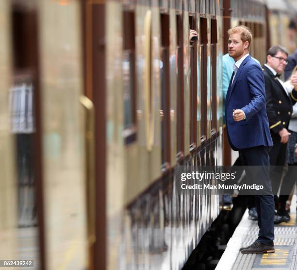 Prince Harry talks to a passenger onboard the Belmond British Pullman train as he attends the Charities Forum Event at Paddington Station on October...