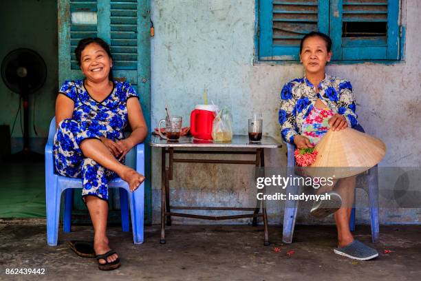 dos vietnamitas mujeres tomando café juntos, delta del río mekong, vietnam - vietnamita fotografías e imágenes de stock