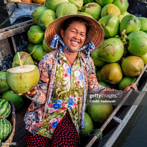 vietnamese vrouw verkopen kokosnoten drijvende markt, mekong river delta, vietnam - asian style conical hat stockfoto's en -beelden