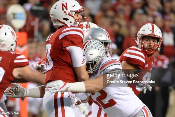 Quarterback Tanner Lee of the Nebraska Cornhuskers takes a hit from linebacker Tuf Borland of the Ohio State Buckeyes after throwing a pass at...