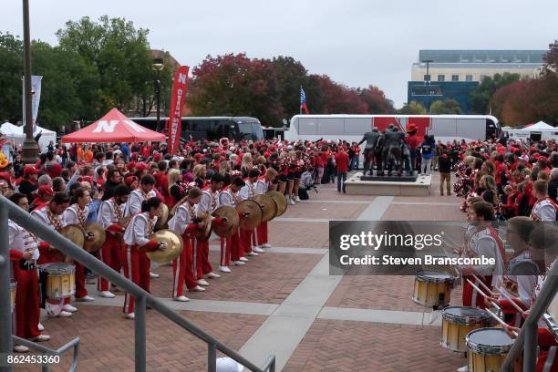 Fans and band members of the Nebraska Cornhuskers cheer on the arrival of the team before the game against the Ohio State Buckeyes at Memorial...