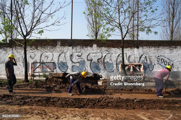 Men work in front of graffiti for candidate Cristina Fernandez de Kirchner in the Hurlingham neighborhood of Buenos Aires, Argentina, on Monday,...