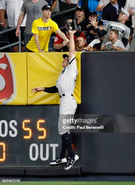 Aaron Judge of the New York Yankees leaps and reaches above the wall in right field to rob Francisco Lindor of a home run in the 6th inning of game 3...
