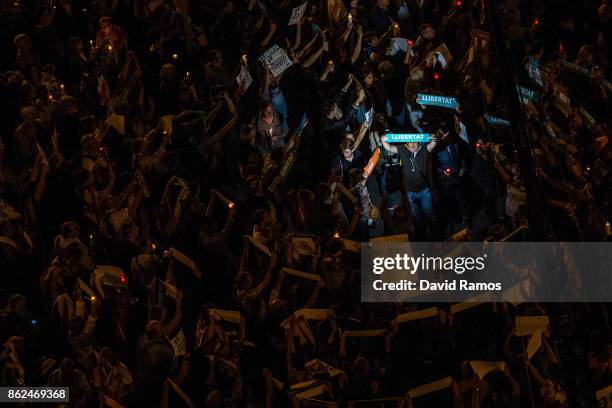 Man holds up a banner that it reads 'llibertat', Freedom in Catalan, as he protests against imprisonment of two key members of the Catalan...