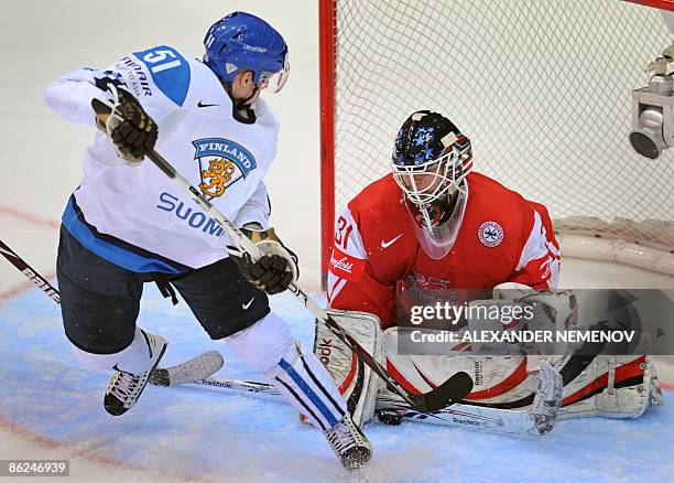 Finland's Juha-Pekka Hytonen vies with Denmark's goalkeeper Sebastian Dahm during their preliminary round group D game of the IIHF Internetional Ice...