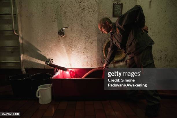 Worker decants the Barolo wine during the fermentation on October 17, 2017 in the Barolo region , Italy. Because of the high summer temperatures,...