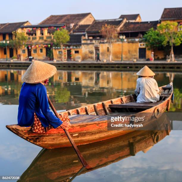 vietnamese women paddling in old town in hoi an city, vietnam - paper lanterns stock pictures, royalty-free photos & images