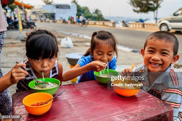 vietnamese kinderen eten een pho bo, zuid-vietnam - ontwikkelingslanden stockfoto's en -beelden