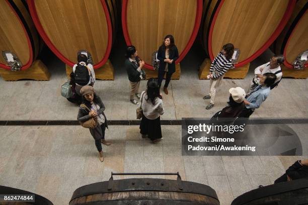 Tourists visit a winery of Barolo on October 17, 2017 in the Barolo region , Italy. Because of the high summer temperatures, Barolo's harvest has...