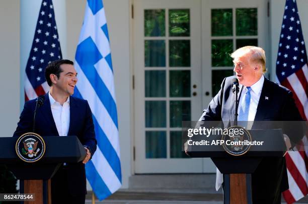 President Donald Trump and Greek Prime Minister Alexis Tsipras share a laugh while addressing the media in the Rose Garden at the White House in...