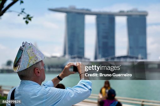 Senior tourist wearing a hat made with a city map Senior tourist wearing a hat made with a city map