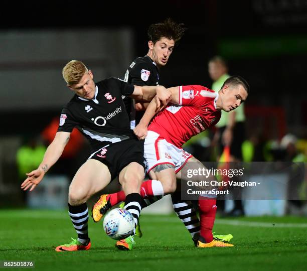 Lincoln City's Elliott Whitehouse, left, with team-mate Alex Woodyard vies for possession with Swindon Town's Donal McDermott during the Sky Bet...