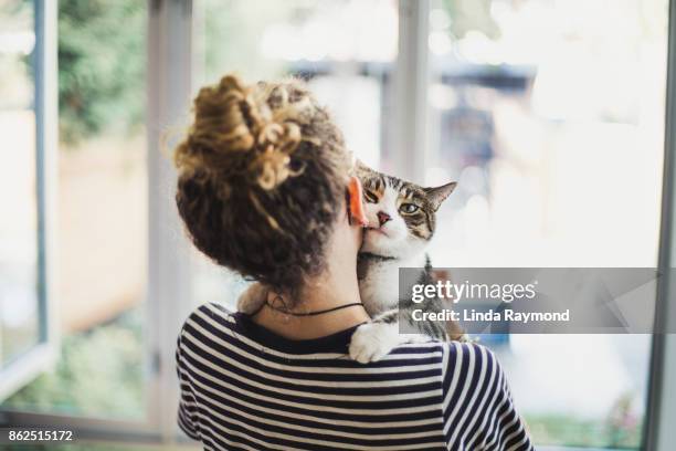 a teenager girl holding her cat - mujer peluda fotografías e imágenes de stock