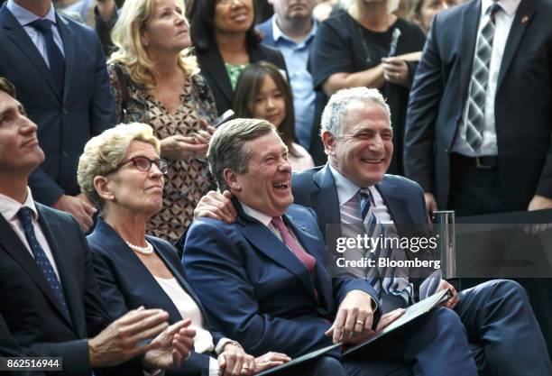 John Tory, mayor of Toronto, center, and Dan Doctoroff, chief executive officer of Sidewalk Labs LLC, right, smile as Kathleen Wynne, premier of...