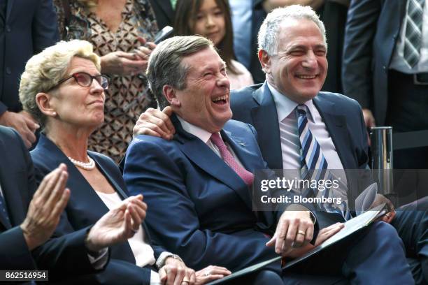 John Tory, mayor of Toronto, center, and Dan Doctoroff, chief executive officer of Sidewalk Labs LLC, right, smile as Kathleen Wynne, premier of...