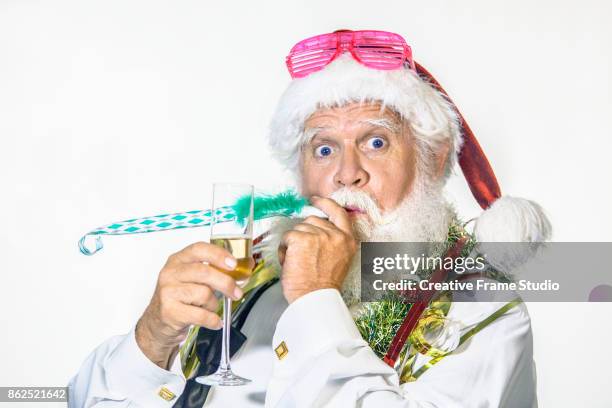 funny santa claus celebrating with a glass of champagne and blowing a party blowout - serpentin bildbanksfoton och bilder