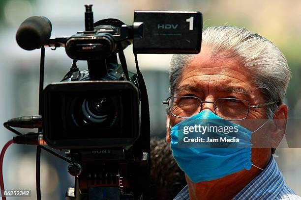 Mexican journalists wear face masks as a prevention against the swine flu virus during a Cruz Azul press conference on April 27, 2009 in Mexico City,...