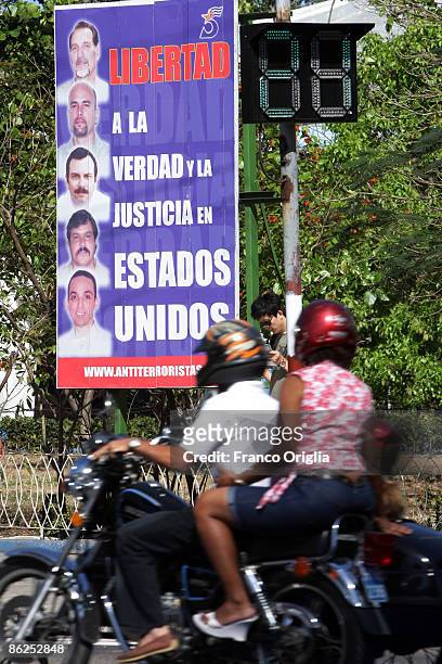 Motorcyclist rides by a banner demanding the release of five Cuban prisoners jailed in the U.S. For more than ten years on April 27, 2009 in Havana,...