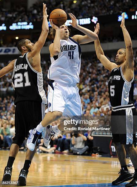 Forward Dirk Nowitzki of the Dallas Mavericks takes a shot against Tim Duncan and Ime Udoka of the San Antonio Spurs in Game Four of the Western...