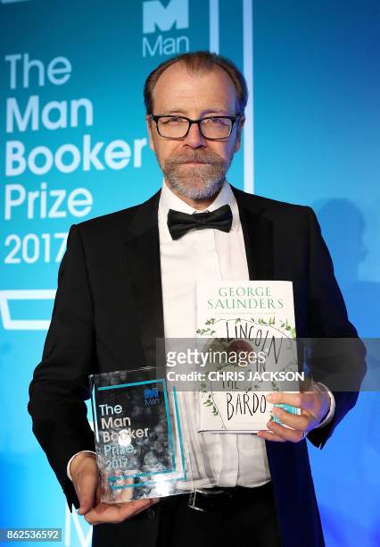 Author George Saunders holds his book and the award for the 2017 Man Booker Prize for Fiction, at the Guildhall in central London on October 17,...