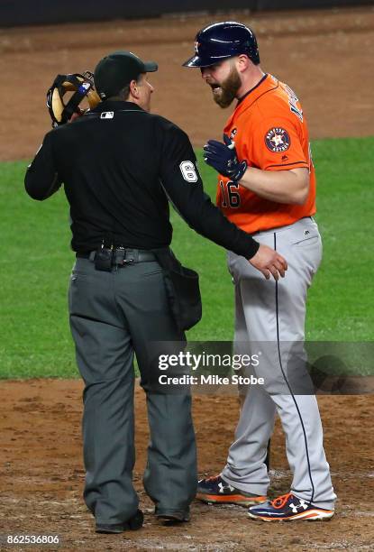 Brian McCann of the Houston Astros speaks to umpire Chris Guccione after striking out against the New York Yankees to end the top of the fifth inning...