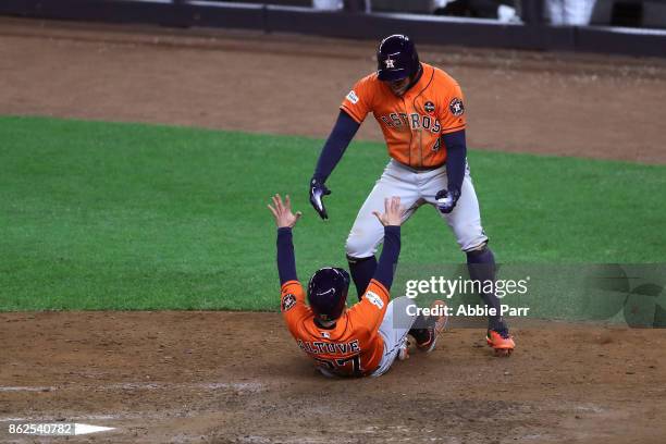 Jose Altuve and George Springer of the Houston Astros celebrate after scoring on a Yuli Gurriel 3-run double during the sixth inning against the New...