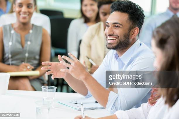 young male business student poses humorous question during lecture - opportunity stock pictures, royalty-free photos & images