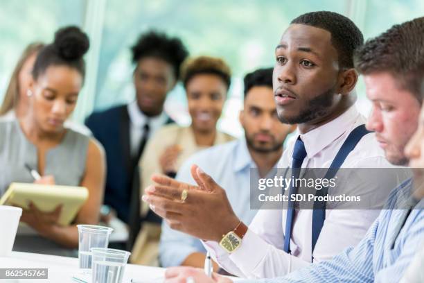 young male business student poses question during lecture - rise from the grave stock pictures, royalty-free photos & images