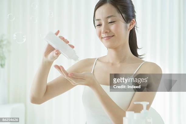 young woman getting lotion to hand - beautiful japanese women stock pictures, royalty-free photos & images
