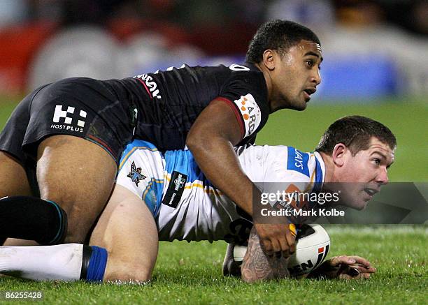 Brett Delaney of the Titans is tackled by Michael Jennings of the Panthers during the round seven NRL match between the Penrith Panthers and the Gold...