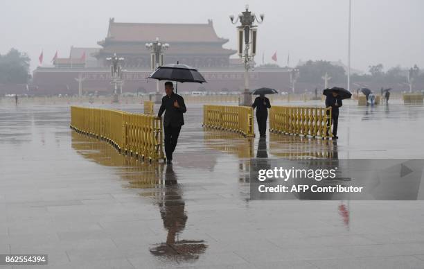 Securuty guards prepare barriers on Tiananmen Square prior to the start of the Communist Party's 19th Congress in Beijing on October 18, 2017. The...