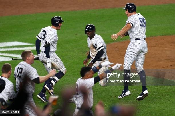 Aaron Judge and Didi Gregorius of the New York Yankees celebrate after scoring on a two-run go-ahead double by Gary Sanchez during the eighth inning...