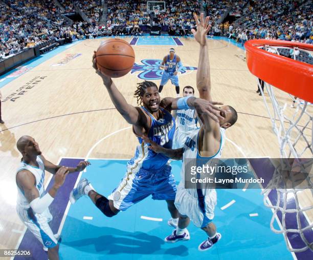 Nene of the Denver Nuggets goes up for a shot over David West of the New Orleans Hornets in Game Four of the Western Conference Quarterfinals during...
