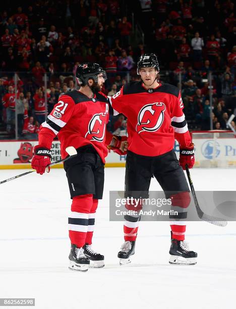 Kyle Palmieri of the New Jersey Devils is congratulated by Damon Severson after scoring a goal against the Tampa Bay Lightning during the game at...