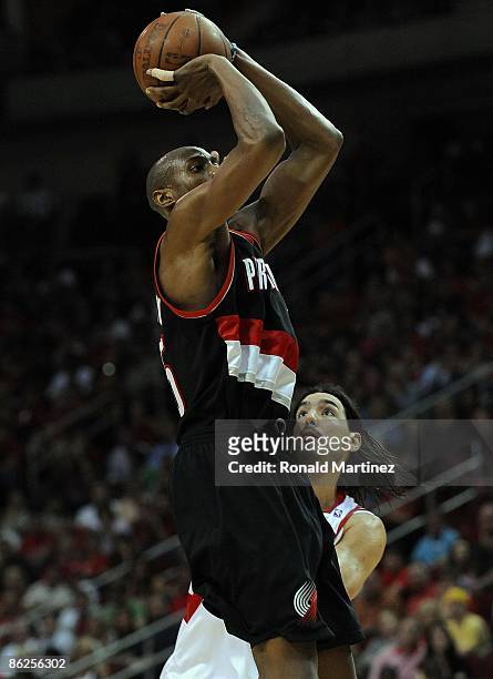 Forward Travis Outlaw of the Portland Trail Blazers takes a shot against Luis Scola of the Houston Rockets in Game Four of the Western Conference...