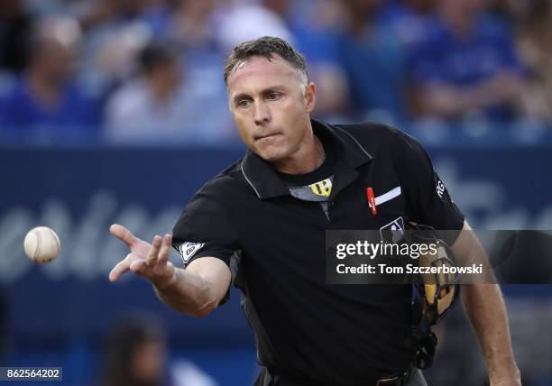 Home plate umpire Dan Iassogna flips a baseball before the start of the inning during the Toronto Blue Jays MLB game against the Tampa Bay Rays at...