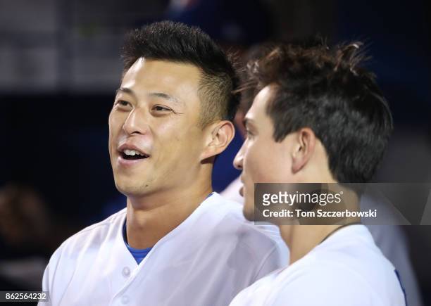 Rob Refsnyder of the Toronto Blue Jays and Darwin Barney look on from the top step of the dugout during MLB game action against the Tampa Bay Rays at...