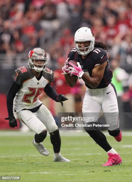 Wide receiver Larry Fitzgerald of the Arizona Cardinals runs with the football after a reception past cornerback Vernon Hargreaves of the Tampa Bay...