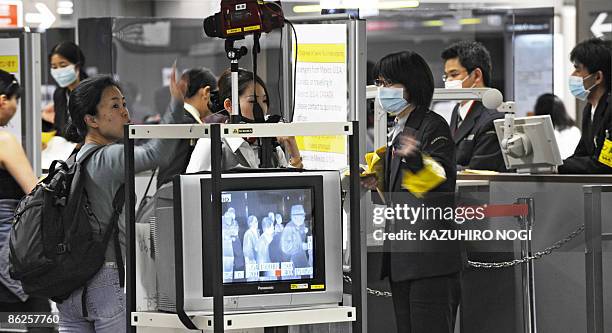 Thermographic device checks the body temperatures of travellers arriving from overseas at a quarantine station at Tokyo's Narita International...