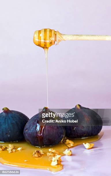 putting honey on fig - aniko hobel 個照片及圖片檔